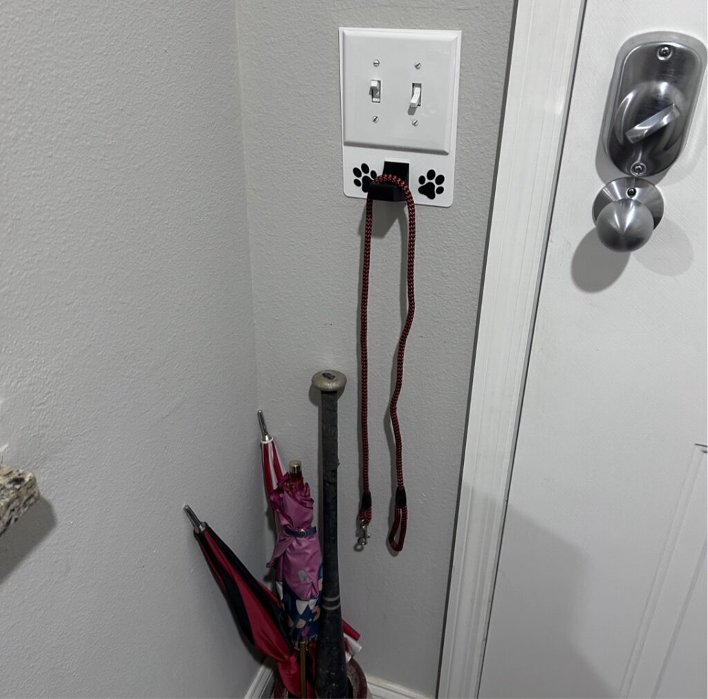 2 gang universal fit dog leash holder for wall mount for underneath outlet wall plate with paw prints - showing use